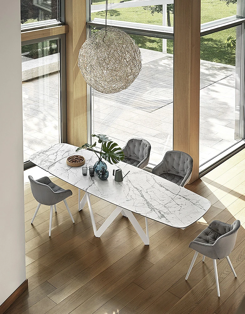 Jasny marmurowy blat stołu z kontrastującymi krzesłami. 