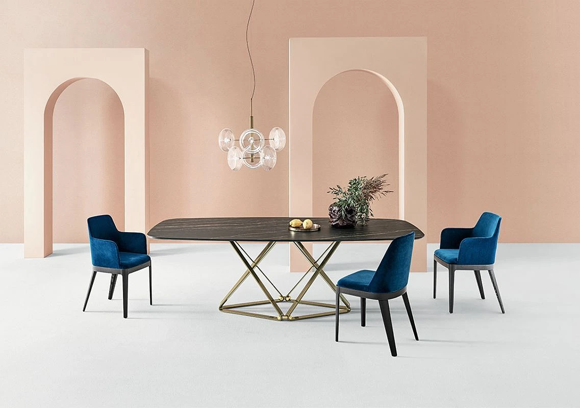 Designerski stół z niebieskimi krzesłami w jasnym pomieszczeniu z białą podłogą i brzoskwiniowymi ścianami.    