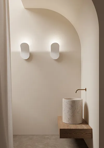 Kinkiety w jasnej łazience bez okien, spełniające funkcję ozdobną oraz dające potrzebne źródło światła.