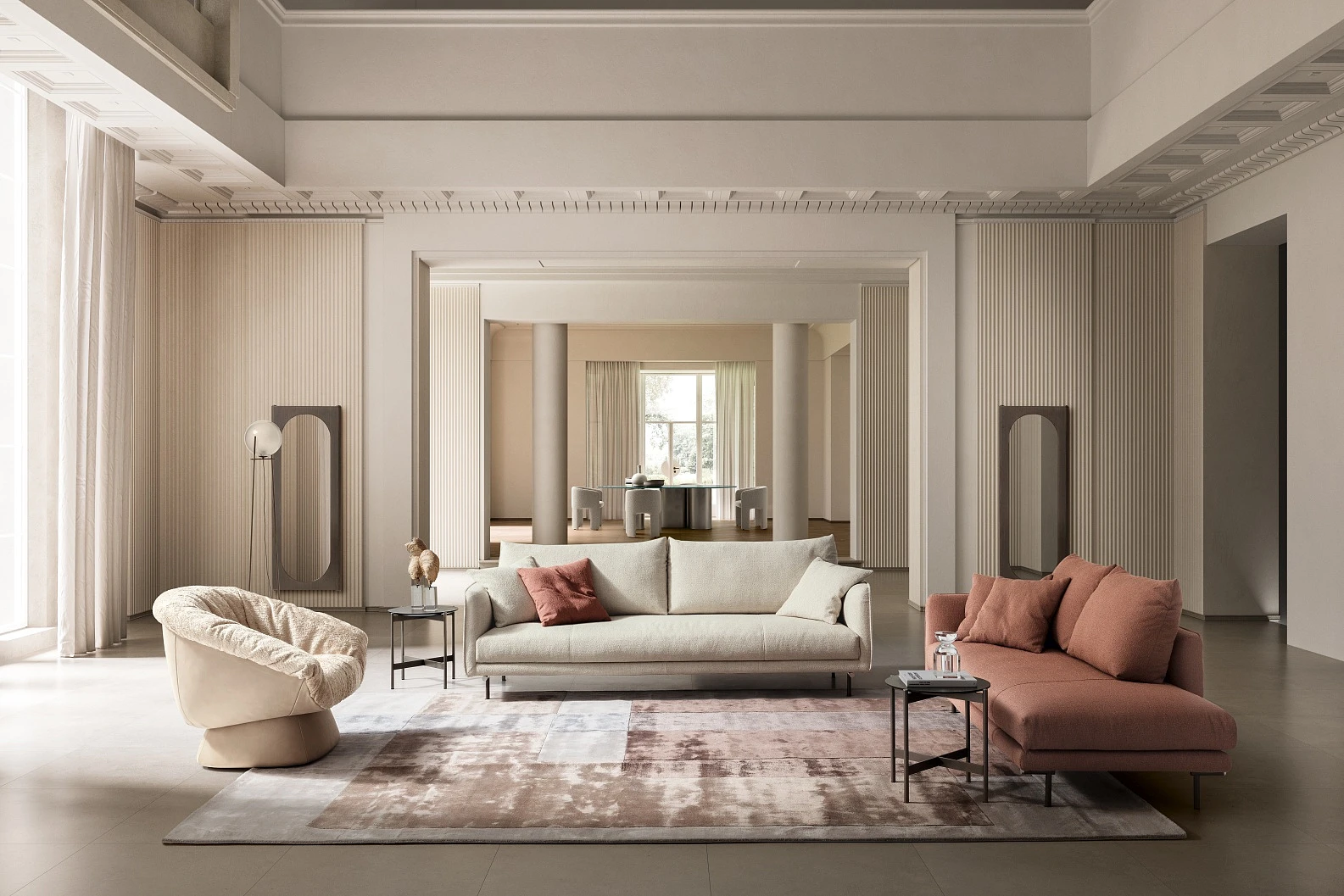 Salon w neutralnej przestrzeni pełnej stonowanych kolorów z dwiema sofami oraz fotelem w beżowych kolorach. 