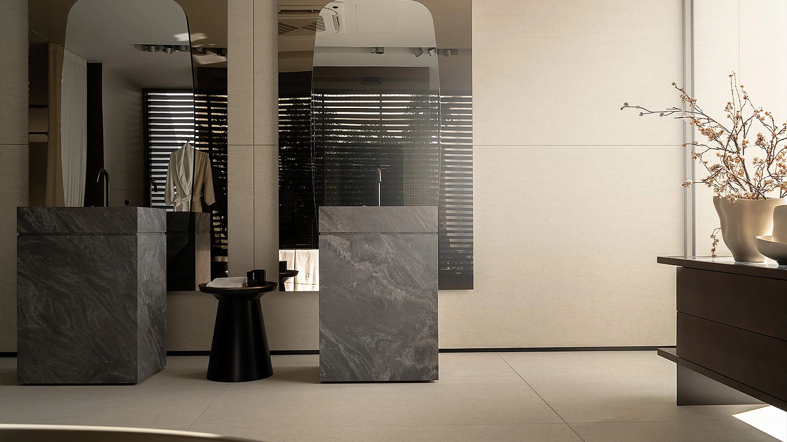 Przestrzenna łazienka o jasnych ścianach, z ogromnymi lustrami oraz wolnostojącymi umywalkami z kamienną fakturą.
